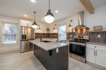 a kitchen with a large island and stainless steel appliances